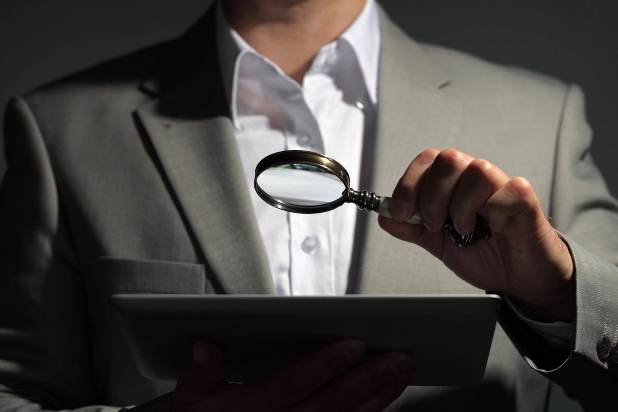 A person holding a magnifying glass